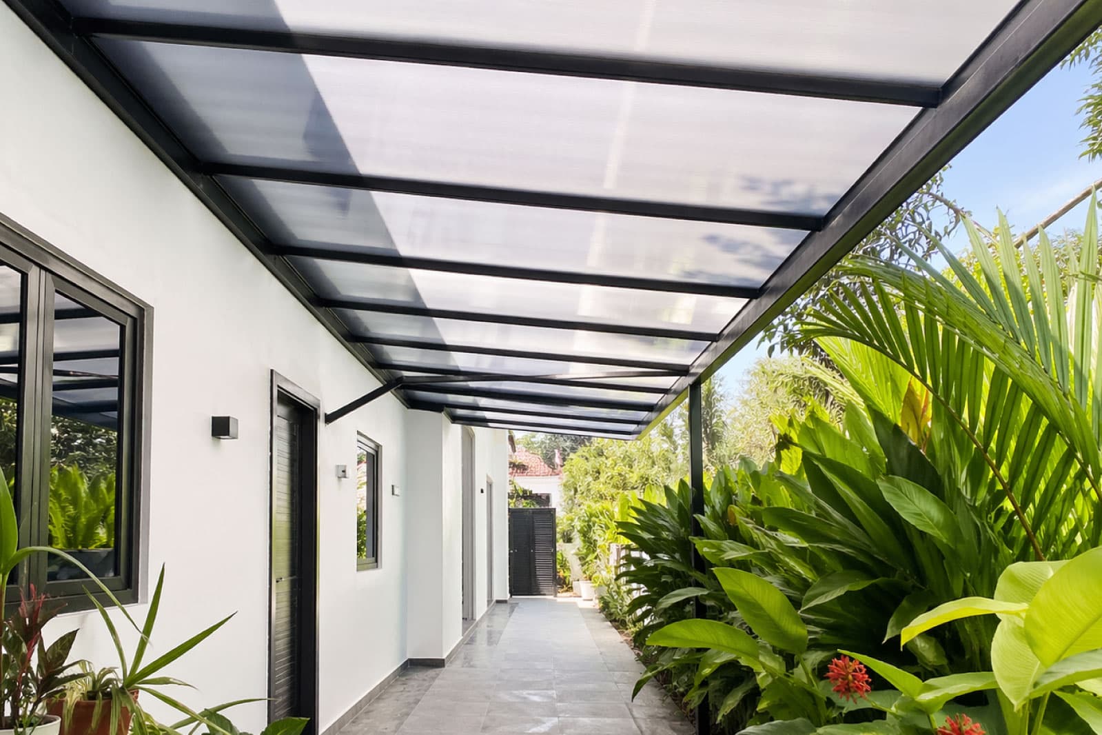 Tinted polycarbonate roof canopy providing bright shelter for balcony